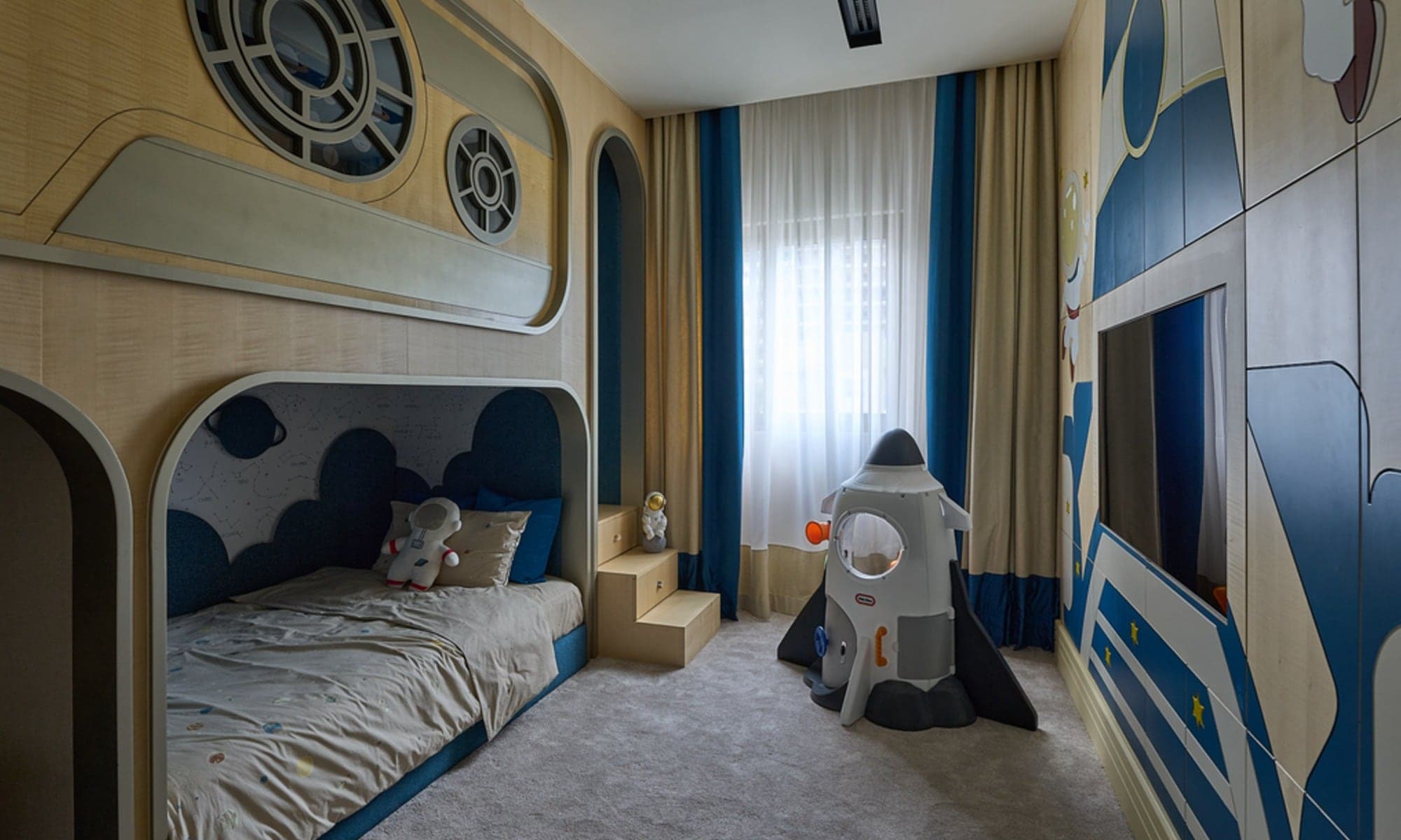 Space-themed children's bedroom with a built-in bunk, porthole detailing and a slide